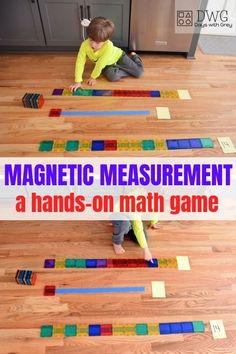 a young boy playing with magnetic measurement tiles on the floor in front of an oven