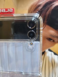 a person holding up a cell phone in front of their face and the case is clear