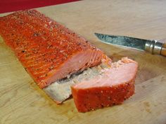 a piece of meat sitting on top of a cutting board next to a knife