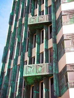 an art deco building with green windows and balconies