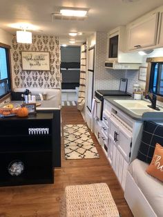 the kitchen and living room are decorated in black and white with pops of orange on the pillows