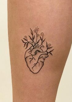 a tattoo on the leg of a woman's thigh with a heart and flowers