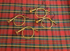 three pairs of scissors are laying on a tartane cloth with gold colored handles