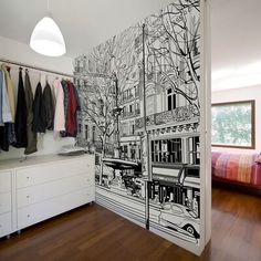 a bedroom with a large mural on the wall next to a bed and closets