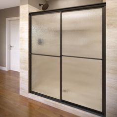 an empty room with wood floors and glass doors on the wall, in front of a white door