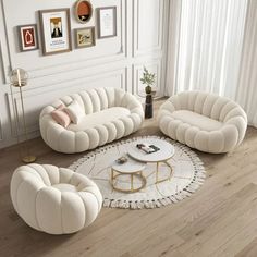 a living room filled with white furniture and decor on top of a hard wood floor