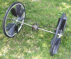 an upside down bike on the ground in the grass with wheels and spokes attached to it