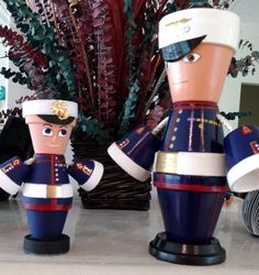 two nutcrackers are standing next to each other in front of a potted plant