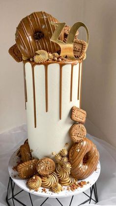 a white and brown cake with chocolate icing on it's top, surrounded by cookies and pretzels