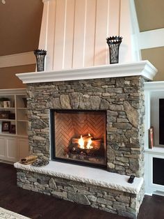 a stone fireplace in a living room next to a tv