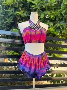 Tie dye outfit 95% Rayon & 5% Spandex. No design on the back of the top Made in Thailand. Top: Fits bust Size 34-40 inches Bottom: Waist-24"-36", Length-9.5 Multicolor Short Swimwear For Festival, Stretch T-back Halter Top For Festival, Summer Rave Style Halter Top For Festivals, Rave Style Halter Top For Summer Festivals, Summer Yoga Crop Top With T-back, Summer Yoga T-back Crop Top, Rave Style Summer Festival Halter Top, Summer Rave Festival Halter Top, Tie-dye Crop Top For Beach And Summer