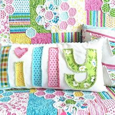 a colorful quilted bed with the word love spelled out in large letters on it