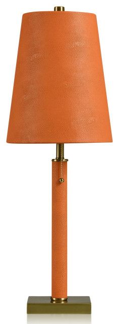 an orange lamp with a gold base and a brown shade on the top, sitting on a white surface