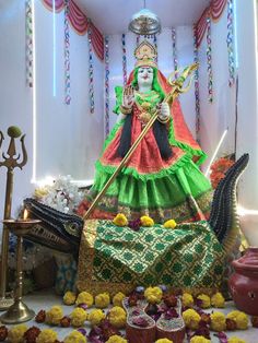 the statue is surrounded by flowers and candles