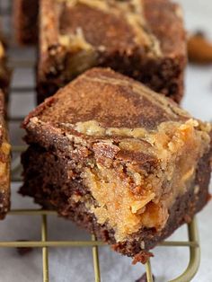 several pieces of brownie sitting on a wire rack with nuts around it and one piece cut in half