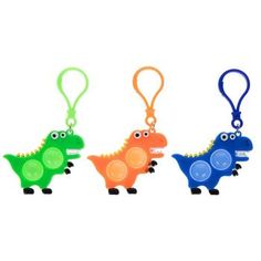 three different colored plastic key chains with small dinosaurs on them, one in the shape of a