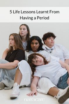 four young people sitting on the floor with one laying down