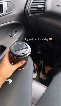 someone is holding the cup in their car