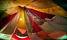 the inside of a tent with many different colored tents hanging from it's ceiling