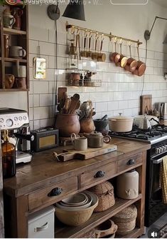 a kitchen with lots of pots and pans on the stove top next to an oven