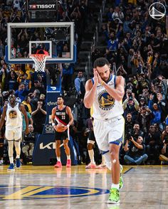 a basketball player walking on the court with his hand up to his face and people watching