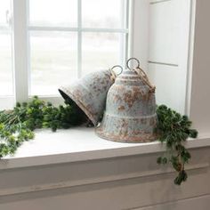 two bells sitting on top of a window sill