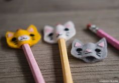 three different colored pencils with cats on them and one has a cat's head