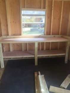 a wooden bench sitting in the middle of a room with wood paneling on the walls