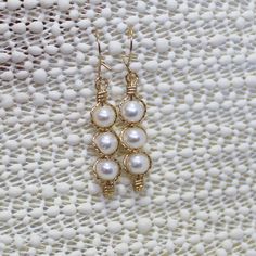 "Three magnificent, shimmery 6mm freshwater pearls, stacked and outlined with 14kt gold filled wire. These silky smooth white pearls glow with elegance, and these eye-catching dangles are sure to get noticed! A fresh look for Spring, an accent for literally any outfit, or the perfect accessory for a blushing bride! They measure 1-5/8\" long including the 14kt gold filled kidney earwires. Pearl is one of the birthstones for June. Can also be made with sterling silver wire." Blushing Bride, Earrings Elegant, June Birthstone, Pearl Earrings Dangle, June Birth Stone, Elegant Earrings, 14kt Gold, Silver Wire, Pearl White