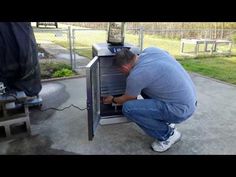 a man bending over looking into an open refrigerator