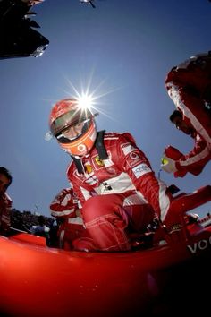 a man sitting in a red car on top of a race track