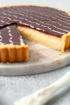 a chocolate cheesecake on a plate with one slice cut out and ready to be eaten