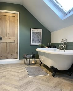 a white bath tub sitting inside of a bathroom next to a wooden door