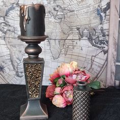 two vases with flowers are sitting next to each other on a black tablecloth