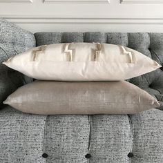 two pillows are sitting on the back of a couch