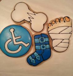 decorated cookies are arranged in the shape of foot, shoe, and wheel chair symbols