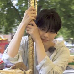 a young man holding onto a metal pole