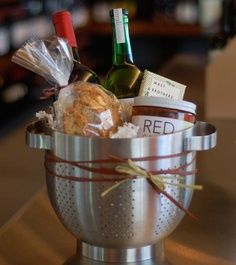 a silver colander filled with food and wine bottles