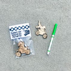 a green pen sitting on top of a piece of paper next to a toy car