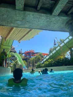 people are swimming in the water at an amusement park