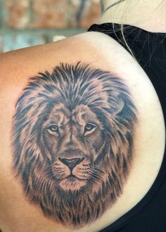 a woman's shoulder with a lion tattoo on the back of her arm and chest