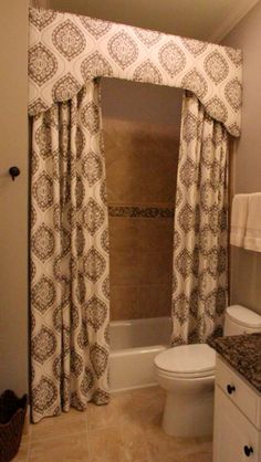 a bathroom with a sink, toilet and bathtub covered in curtained drapes