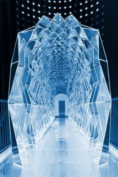 an abstract photo of a hallway in a building with blue lighting and mirrors on the walls