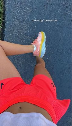 a woman's legs and shoes are seen from above, with grass in the background