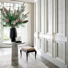 a vase filled with flowers sitting on top of a table next to a chair and window