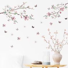 a vase filled with flowers sitting on top of a table next to a white wall