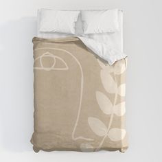 an unmade bed with white linens on it and a plant design on the comforter