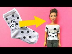 the doll is wearing a white shirt and black polka dot socks with a cat on it