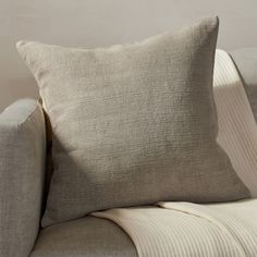 a beige pillow sitting on top of a couch