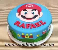 a blue cake with mario on it sitting on top of a table